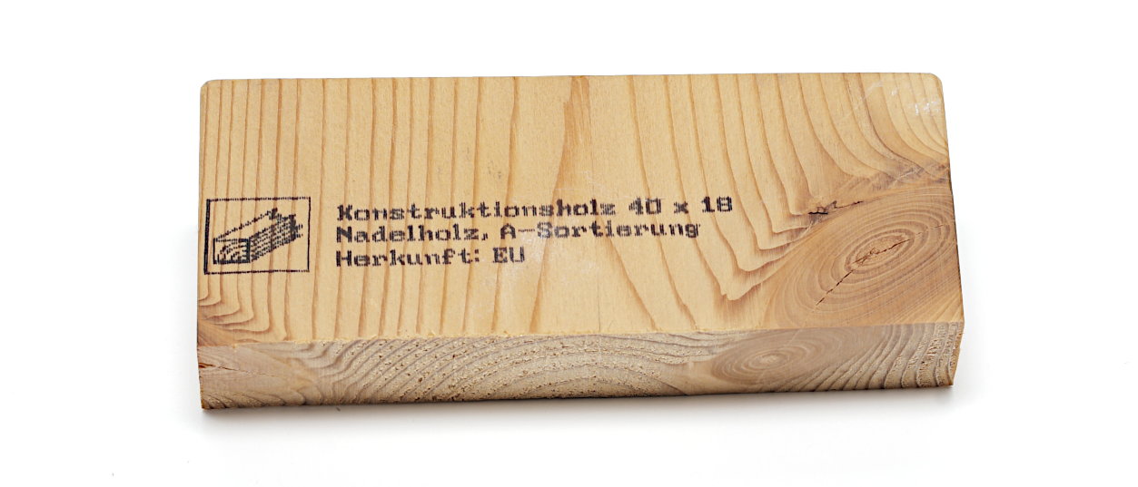 Beschriftetes Nadelholzstück.